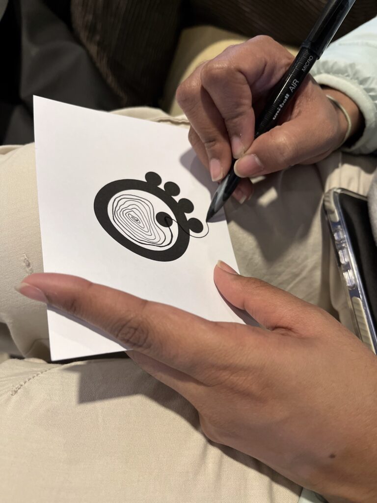 Ansichtkaart met cirkel (logo Inclusively Wired) wordt met penlijnen ingetekend