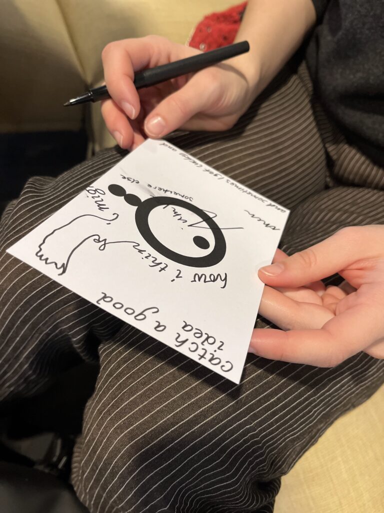 ansichtkaarten met cirkel en handgeschreven tekst, wordt door twee handen vastgehouden